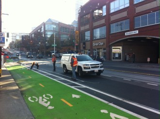 SDOT crews install finishing details to make the bikeway more intuitive to use