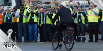 Bennett rides a bike again, this time during the team's sendoff celebration as they head to the Super Bowl