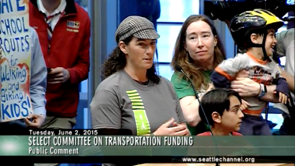 Morgan Scherer of Family Bike Seattle testifies at the hearing. With her: Margaret McCauley and kids. Community support expanded Safe Routes to School funding in the levy plan.