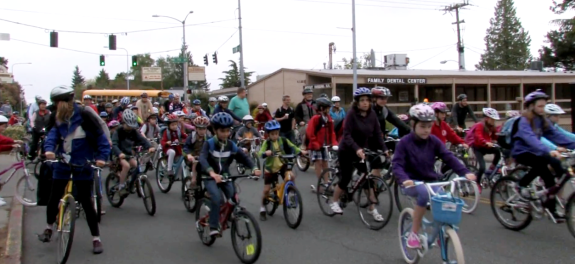 A large group of elementary age kids biking to school.