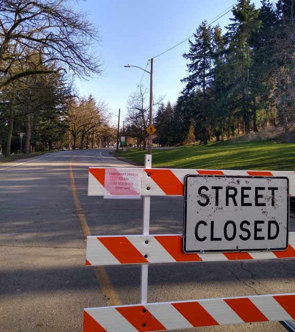 Street closed sign in front of two lane road