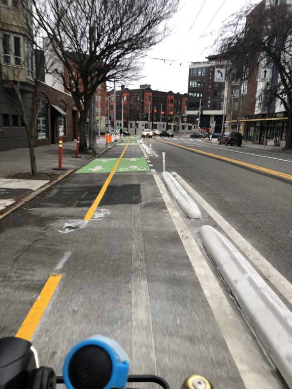 Photo of the new bike lane on 1st, which is separated from car traffic by a concrete curb.