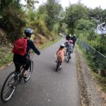 Photo of parents and kids biking on a trail together.