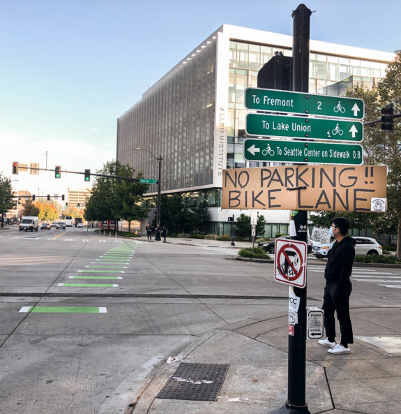 Photo of a handwritten sign on a sign post that says "no parking bike lane."
