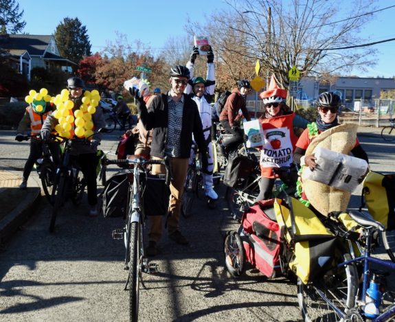 Riders posing with donations, including one dressed as a taco