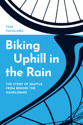 Book cover for Biking Uphill in the Rain. At top is a close-up illustration of the lower part of a bicycle wheel. The lower part has a blue background and a distorted bike wheel illustration that resembles a reflection in a puddle.
