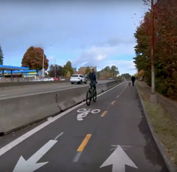 Photo of the Green Lake bike lane on Aurora with a cement barrier about three feet high designed for highway traffic.