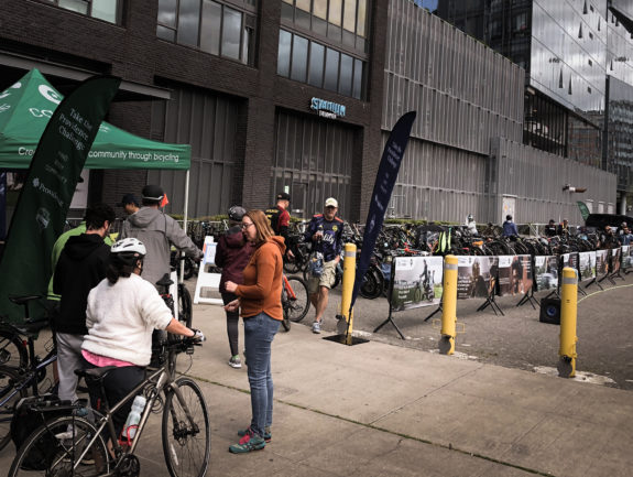 Photo of people with bike checking in with people running the long and busy bike corral area.