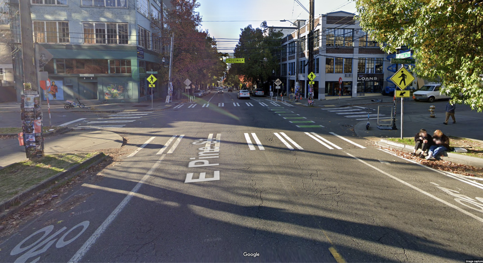 Google Street View image of Pine at Boylston, which has crosswalk signs all around it as well as a green bike lane. 