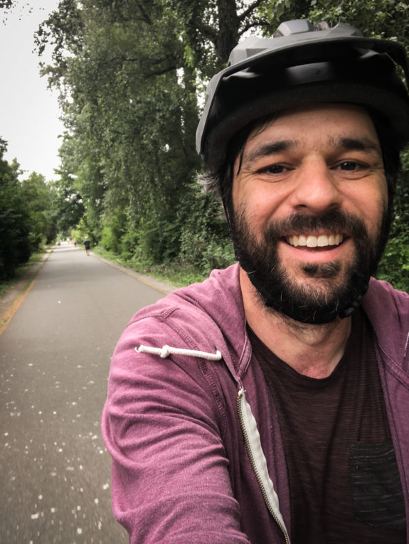 Selfie of the author biking on an open trail.