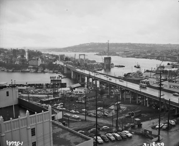 Archive black and white aerial photo of the University Bridge and nearby area, which was mostly filled with parked cars and industrial uses.