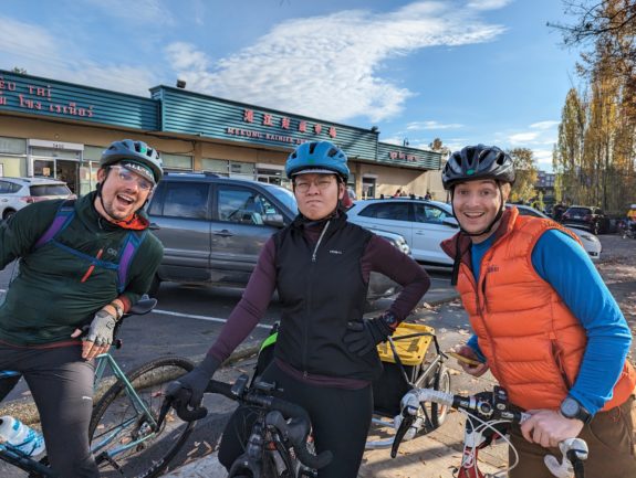 Three people with bikes smiling for the camera.